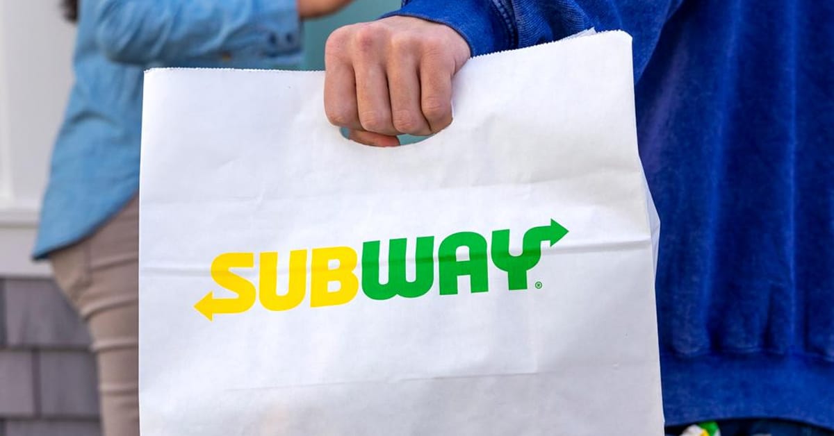 A person holding a Subway to-go bag