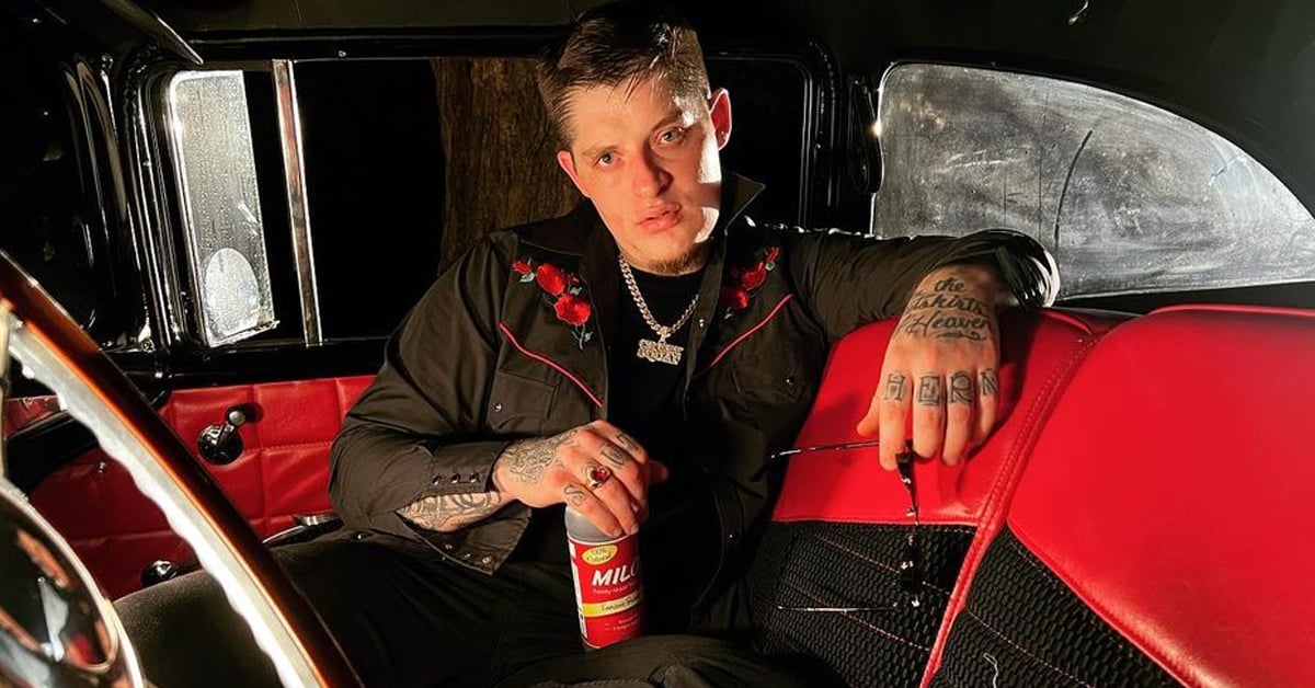 Ryan Upchurch holding a drink bottle and a pair of eyeglasses inside a car