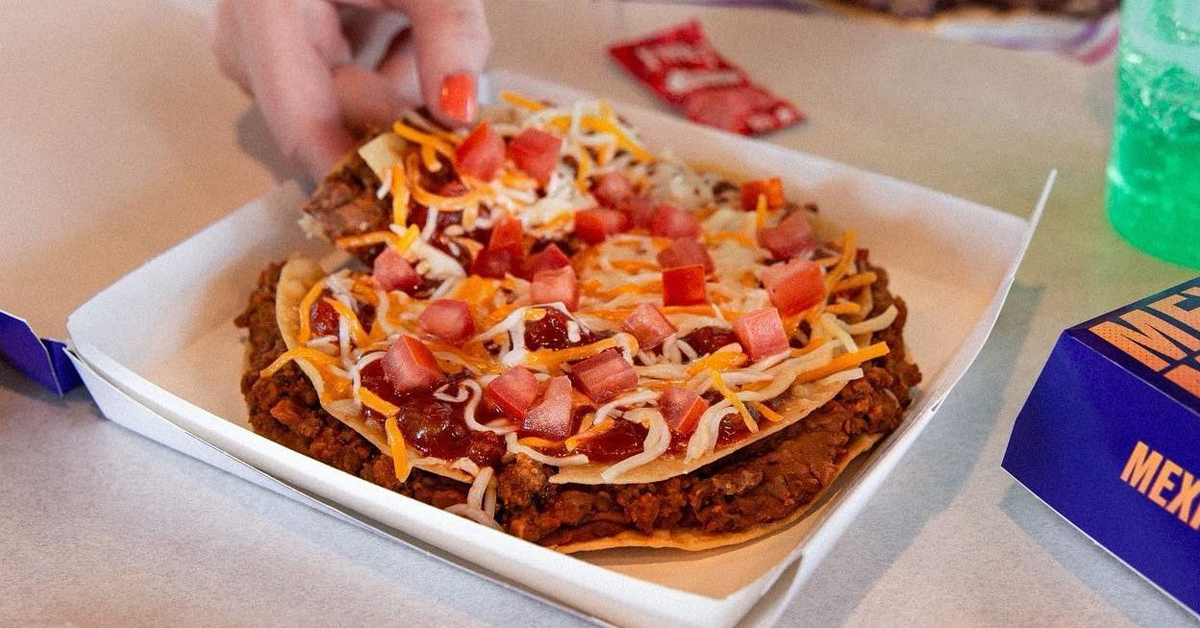 Hand getting a slice of Taco Bell Mexican Pizza