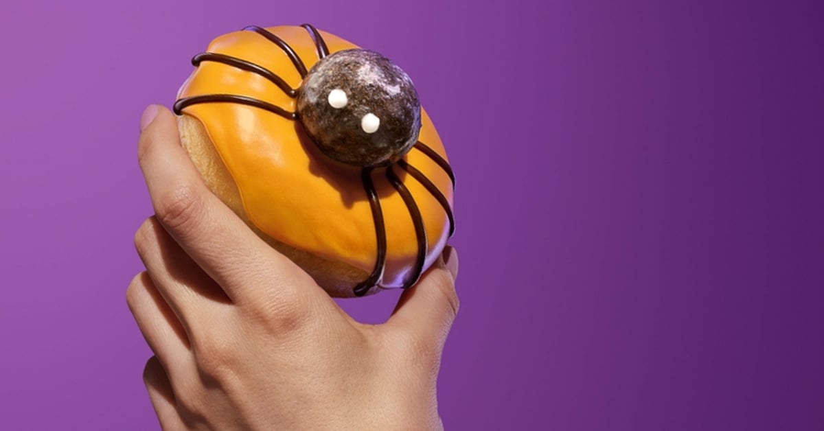 A hand holding a Spider Donut from Dunkin'