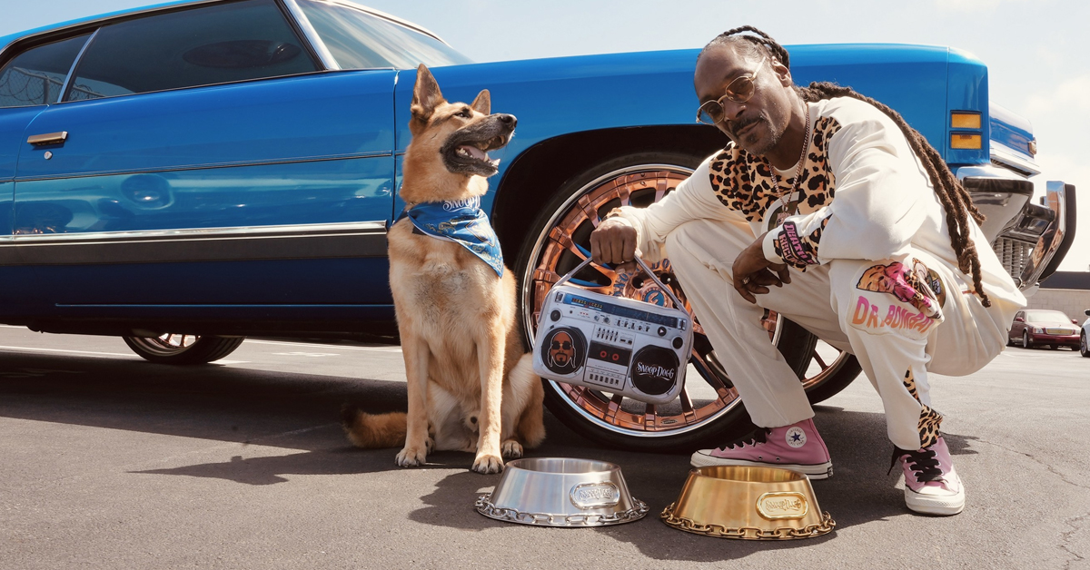 Snoop Dogg and a dog with some products from the Snoop Doggie Doggs collection