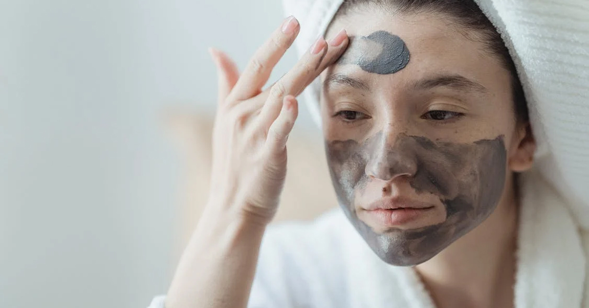 Woman applying what appears to be a latte coffee sleeping mask