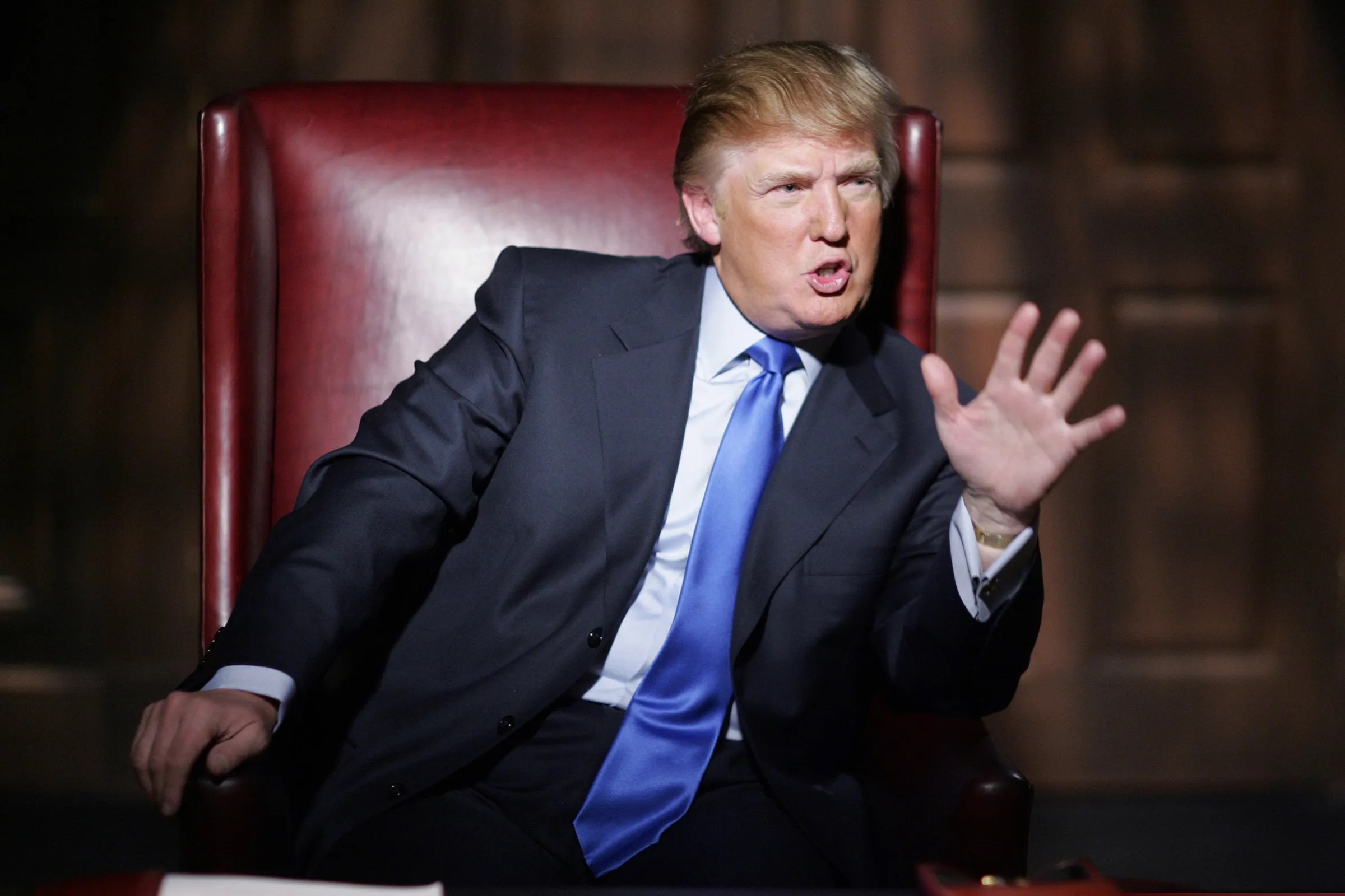 Donald Trump, host of the original The Apprentice, in the iconic boardroom chair | ©Image Credit: NBC / Everett Collection