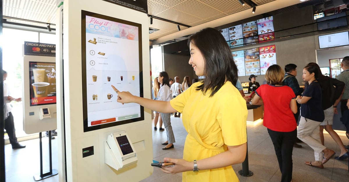 A woman placing her order through a McDonald's self-ordering kiosk | ©Image Credit: McDonald's