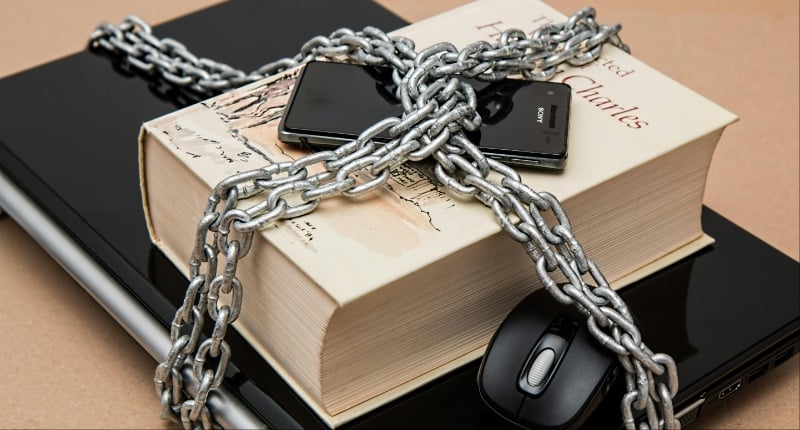 Laptop, book, cellphone, and mouse chained together | ©Image Credit: Pexels / Pixabay