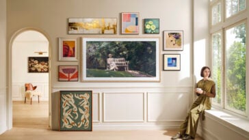 Samsung Frame Pro TV displaying digital art and surrounded by other framed artworks, demonstrating the Frame Pro's ability to pass as an art piece
