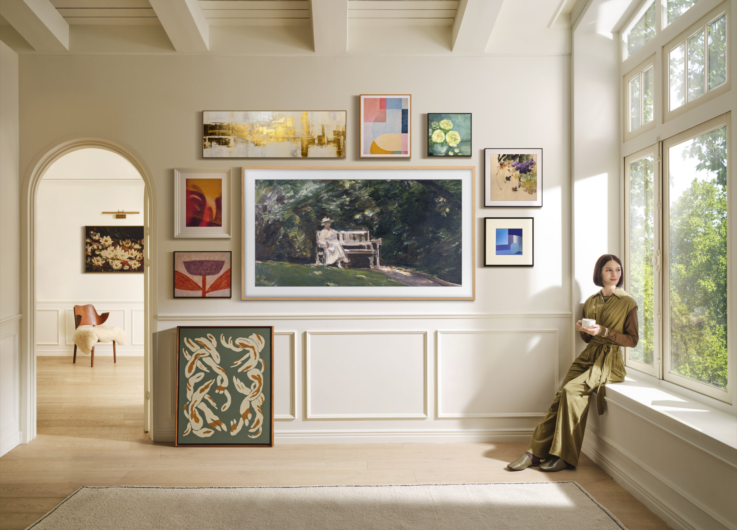 Samsung Frame Pro TV displaying digital art and surrounded by other framed artworks, demonstrating the Frame Pro's ability to pass as an art piece