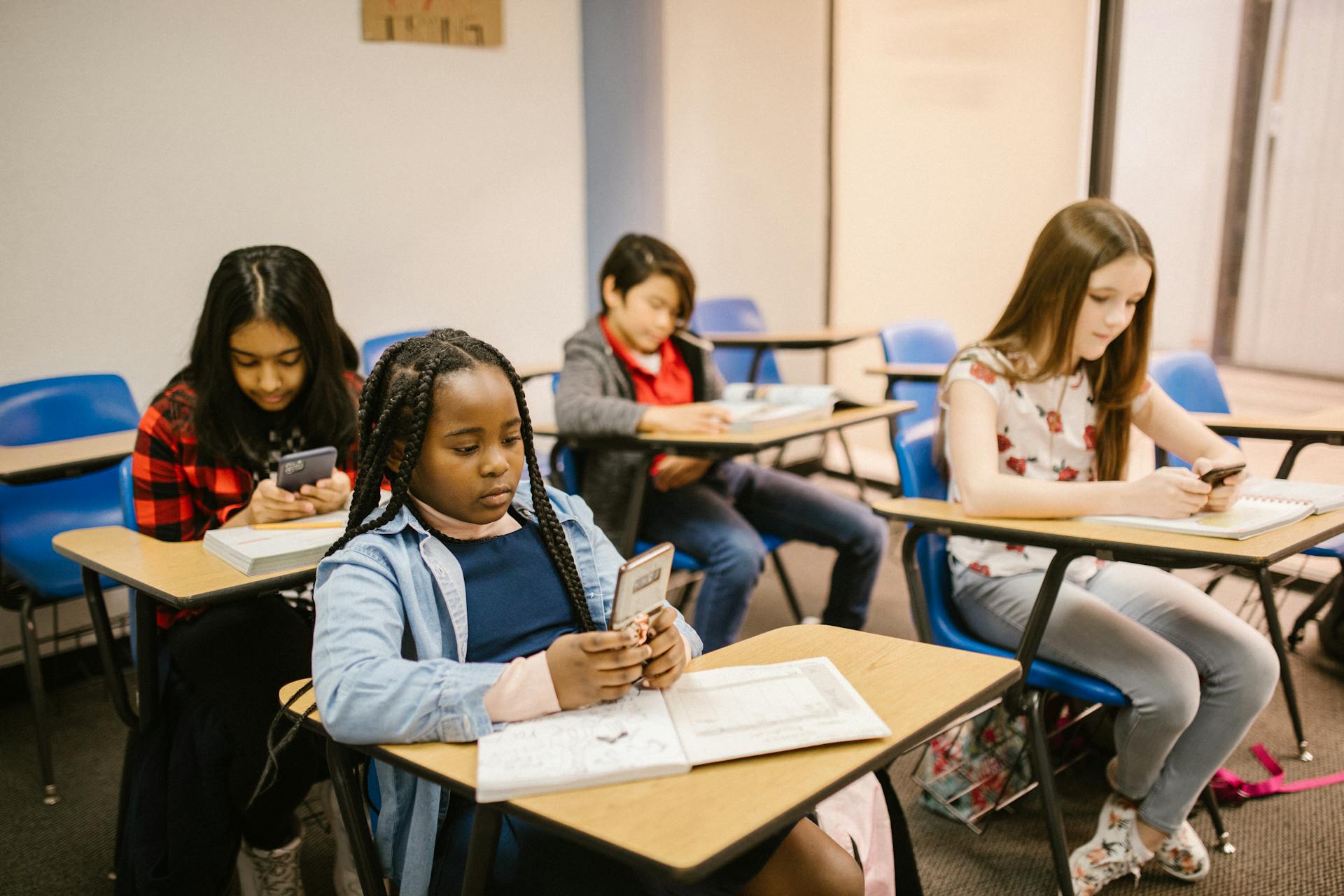 Students sitting inside the classroom while using their smartphones | ©Image Credit: RDNE Stock project/Pexels