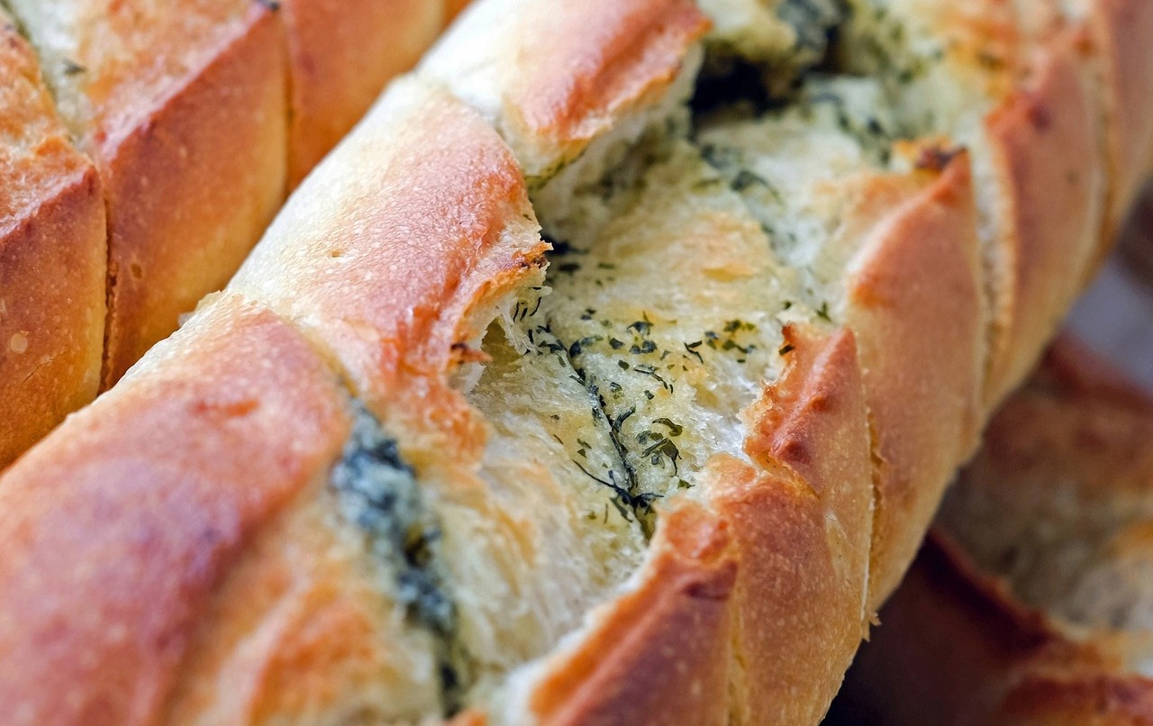 Close-up of a loaf of pull-apart garlic bread with sliced sections | ©Image Credit: PxHere