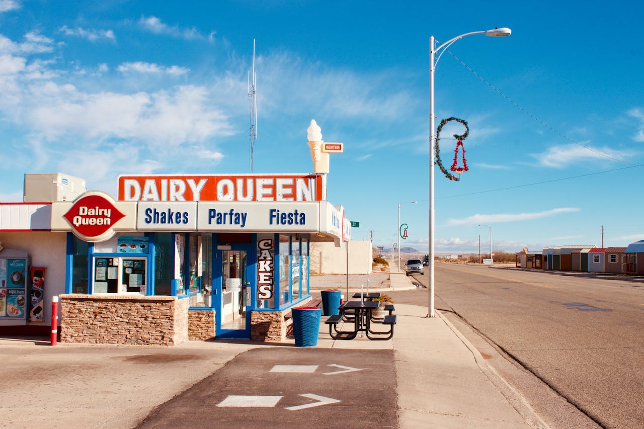 A Dairy Queen restaurant with classic red and white signage located on a quiet desert highway | ©Image Credit: Pexels / Austin Cooper