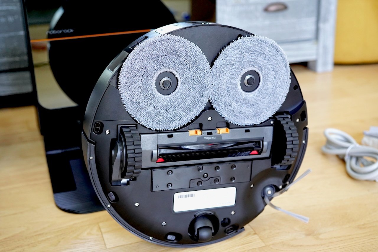 Bottom view of Roborock Saros Z70 showing dual spinning mop heads, wheels, and central suction area