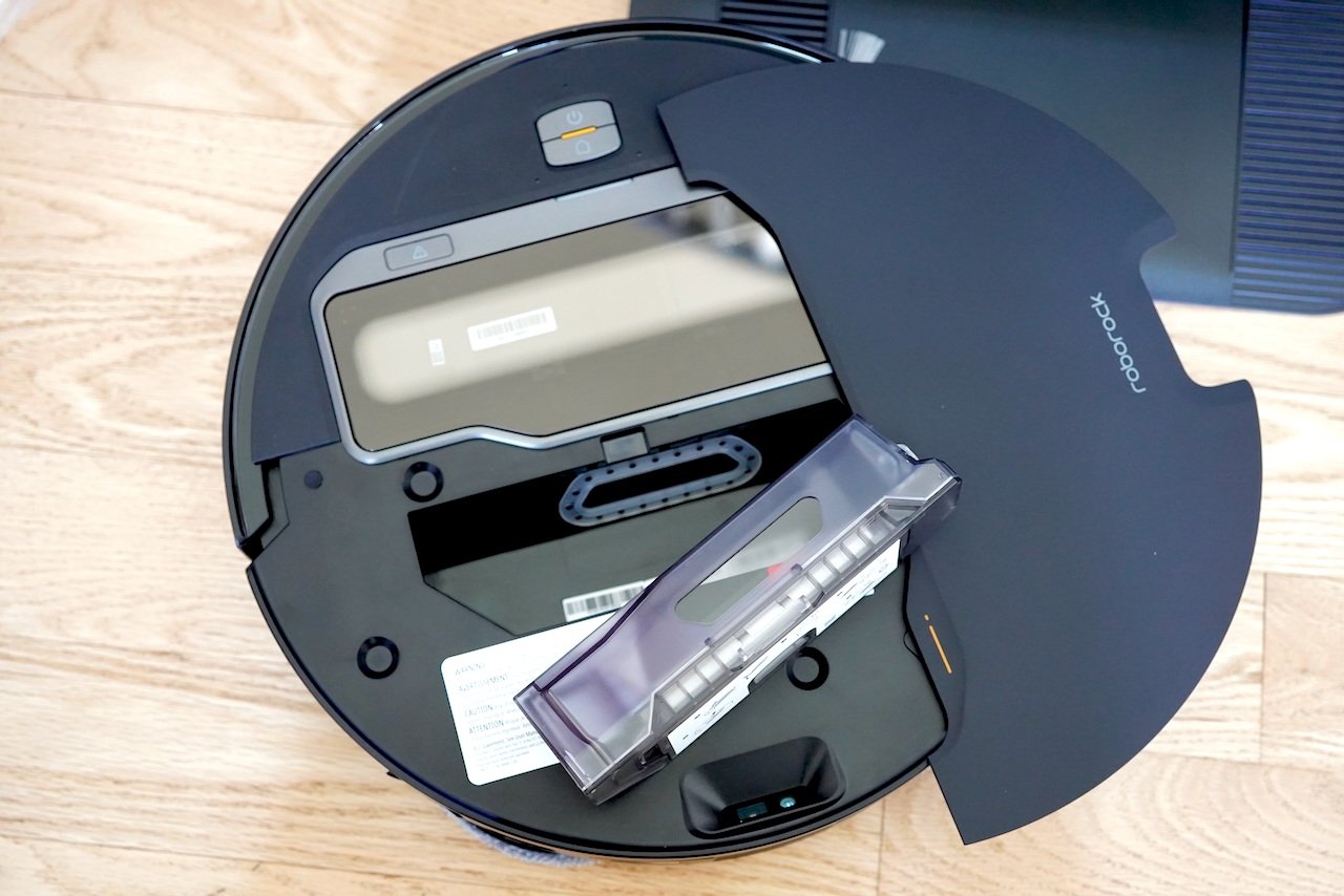 Top-down view of black Roborock Saros Z70 with compartment open revealing internal dustbin and water tank 