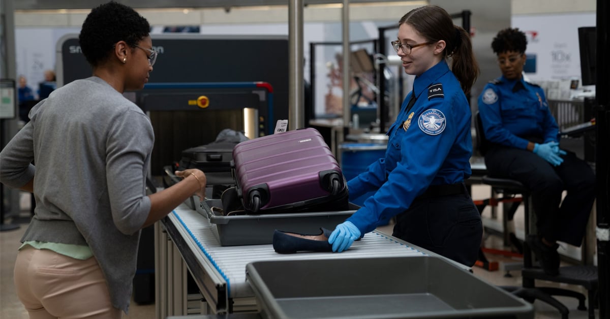 A TSA officer inspects a traveler’s belongings including her shoes at a security checkpoint | ©Image Credit: Transportation Security Administration