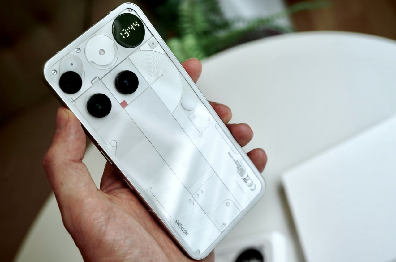 Hand holding Nothing Phone 3 displaying Glyph interface functionality and its full transparent back