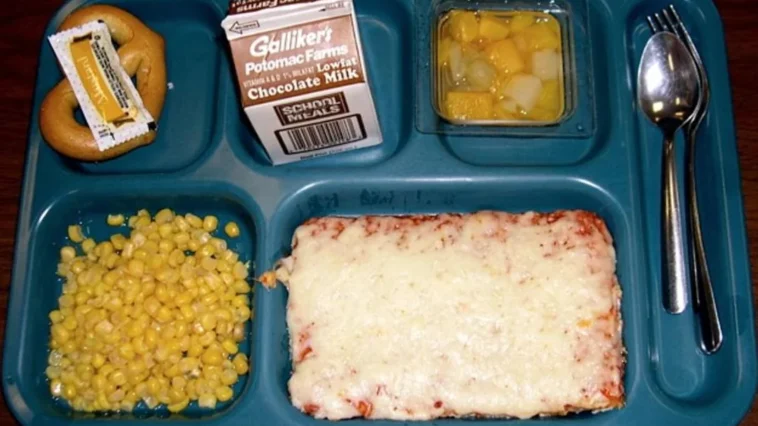 School lunch from the '80s featuring cheese pizza, corn, pretzel with mustard, fruit cocktail, and chocolate milk | ©Image Credit: Reddit / HistoricalCapsule / zadraaa