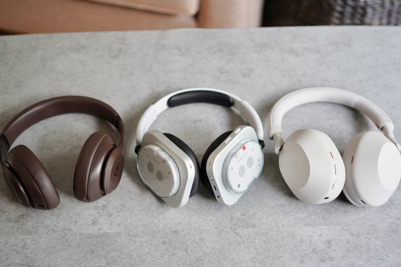 Nothing Headphone (1) Review: The glorious return of buttons and dials 4 Three over-ear headphones side by side comparison showing Sony WH-1000XM5 headphones (brown), Nothing headphones (white/clear), and Apple AirPods Max headphones (beige)