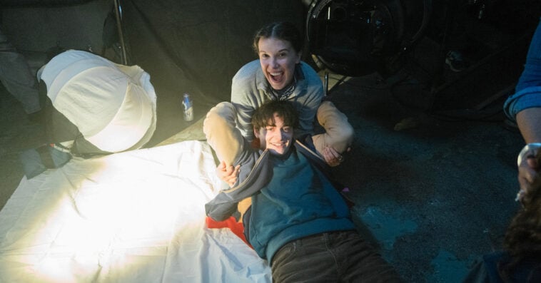 Millie Bobby Brown and Noah Schnapp share a playful moment behind the scenes of One Last Adventure: The Making of Stranger Things 5 | ©Image Credit: Atsushi Nishijima/Netflix