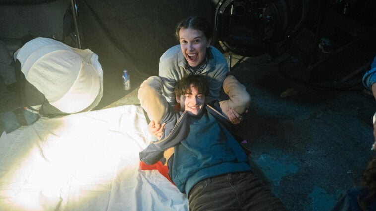 Millie Bobby Brown and Noah Schnapp share a playful moment behind the scenes of One Last Adventure: The Making of Stranger Things 5 | ©Image Credit: Atsushi Nishijima/Netflix