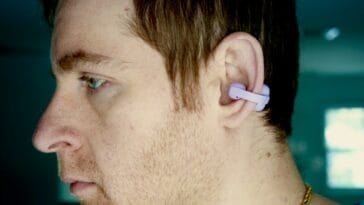 Side profile of a person wearing the Sony LinkBuds Clip in lavender, showing how the earbud clips onto the outer ear without any insertion