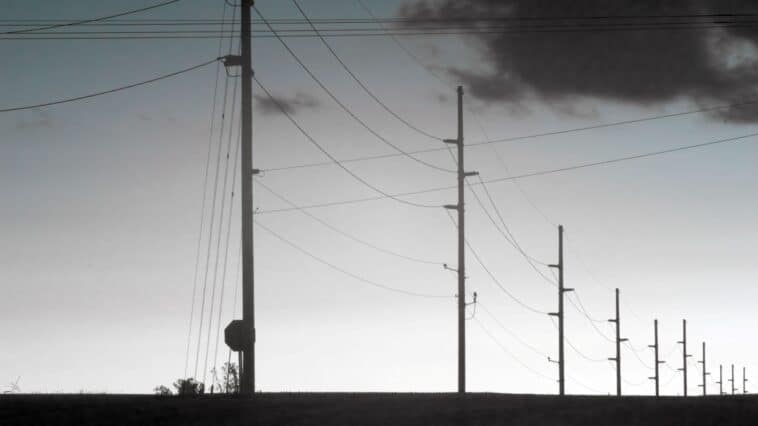 Overhead utility lines stretch along a row of poles | ©Image Credit: Pexels / Tom Fisk
