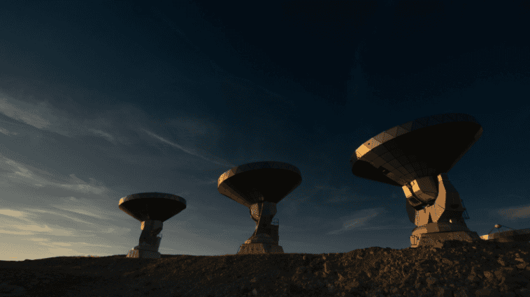 Top scientists warn never to reply to alien contact 1 A row of radio telescope dishes silhouetted against a twilight sky, representing SETI research facilities | ©Image Credit: Unsplash / Thanh Nguyen