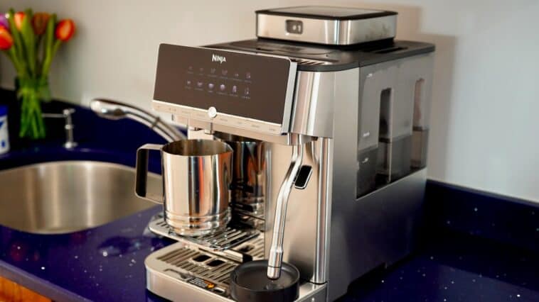 Front angle view of the stainless steel Ninja AutoBarista Pro espresso machine sitting on a kitchen countertop