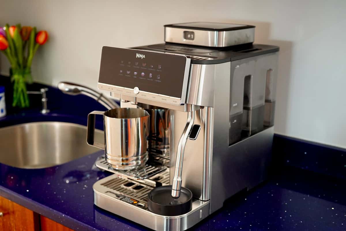Front angle view of the stainless steel Ninja AutoBarista Pro espresso machine sitting on a kitchen countertop