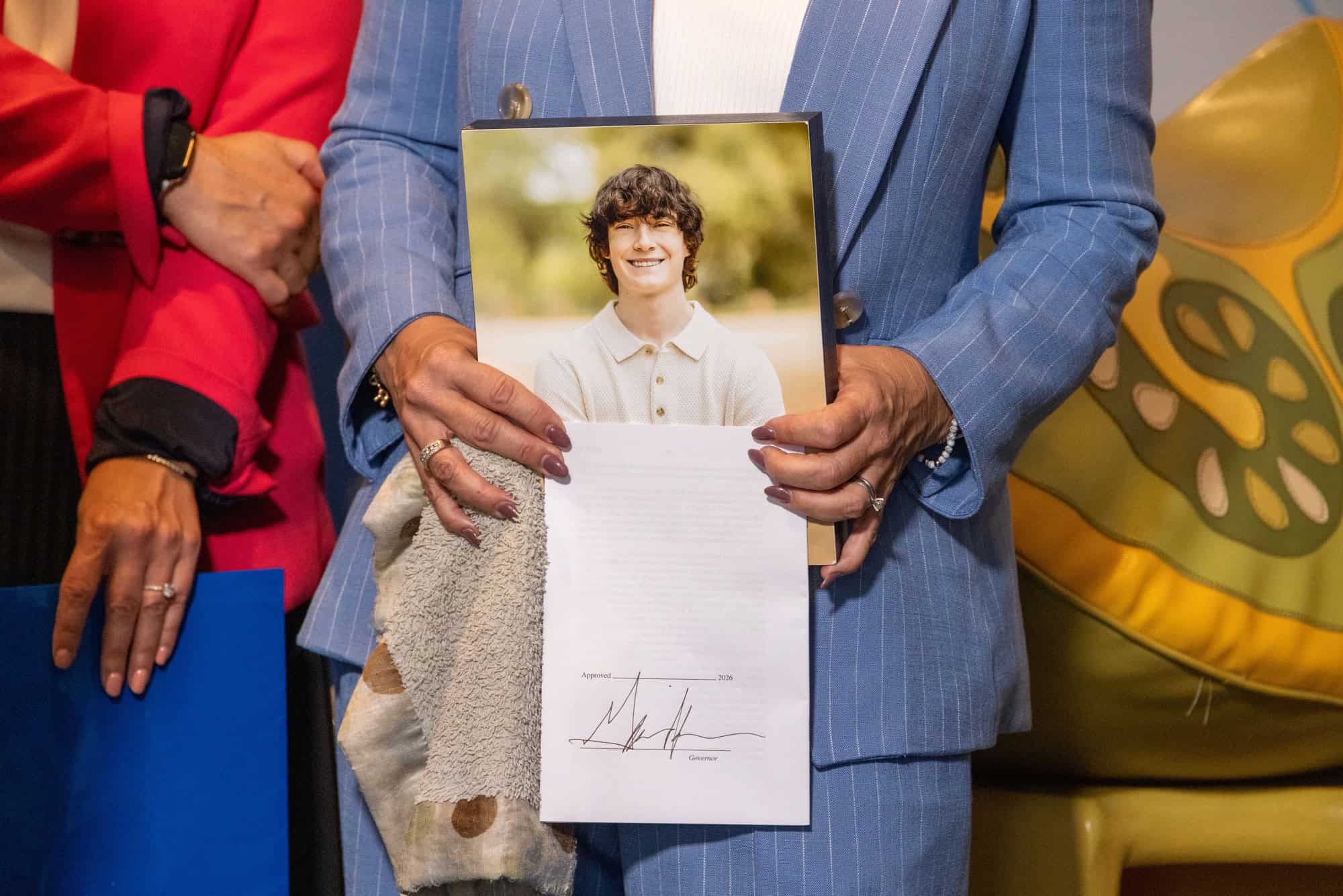 The new AI law is named after Adam Raine, a teen who died by suicide. Raine’s mother said he was "coached" by an AI. ©Image Credit:Governor Gavin Newsom’s Office